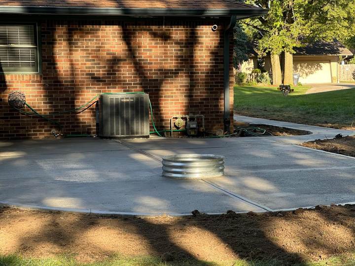 Patio with a fire pit ring at a brick home