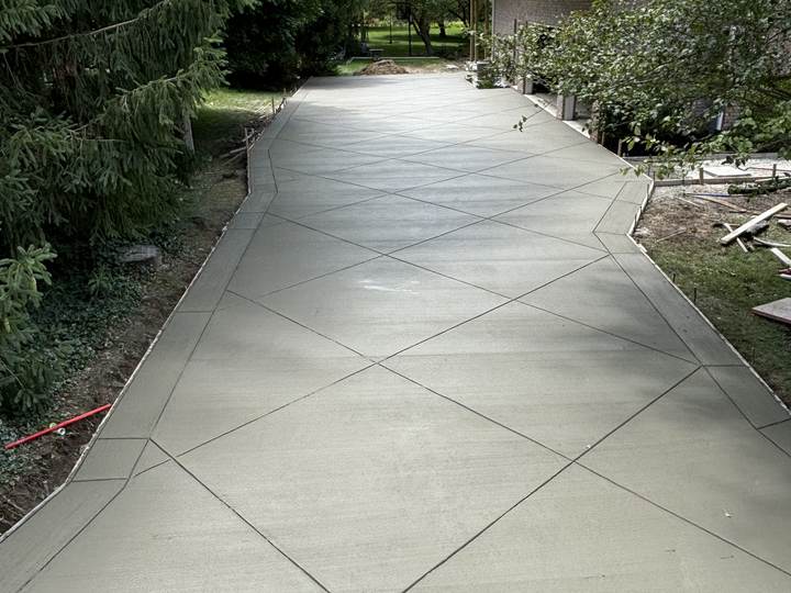 Wide curving broom finish driveway to a two storey home in Zionsville, Indiana